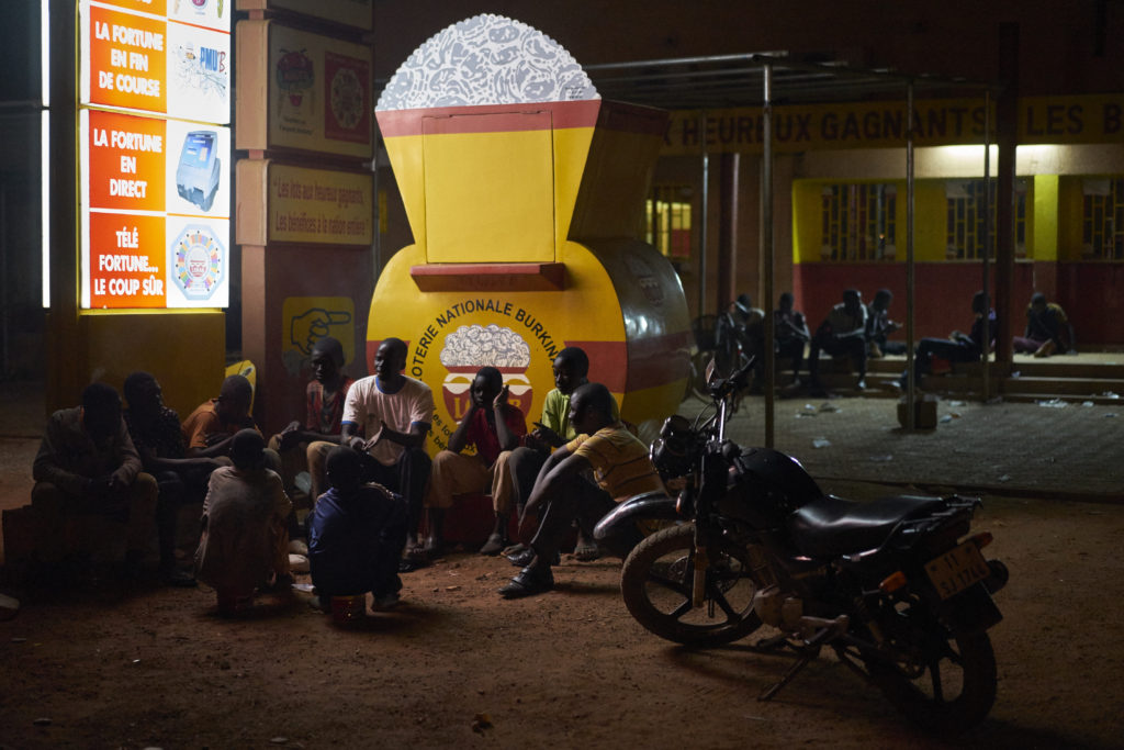 Elie Moussa Tiendrebeogo and Tasséré Ouedraogo engage boys talk with boys living on the streets in Ouagadougou, Burkina Faso on October 5th, 2016. Elie and Tasséré are from "Association de Jeunes et enfants vivant dans le rue face à leur sort". PDEV supported the association with materials including motorbikes, desk, chairs and other office equipment and workshops in peace-building. Some of the boys ended up on the street having fled Koranic school, some were victims of domestic violence and others orphans. The boys at this particular site are between 13 and 18 years old and sleep here because the night guard permits their presence and offers some form of protection from street violence. The kids talk about their problems at the moment they are facing and the social workers take these into consideration and actions that can be taken to resolve them. During the day they search everywhere for scrap metal that they can sell for about 5-6000 CFA. Tasséré Ouedraogo Executive Secretary says The associations objective is to assist children who are living in the streets. We were street kids ourselves so when we got off the streets and started working we wanted to do something to help others like us. We identified 45 sites in the city where you will find street kids and then identified one of the kids from each site as a team leader. We realised that it is important to find a leader amongst the kids who could raise important issues related to hygiene, health and substance abuse. In the past what happened was the kids were stigmatised when there were thefts in the community. We realised that our activities alone would not be sufficient to help these children out of their situation and we needed to engage the community, without this assistance the kids can't get off the streets and they will keep being stigmatised. We created football matches that were played in each neighbourhood, it allowed the children to make friends in these neighbourhoods with other kids