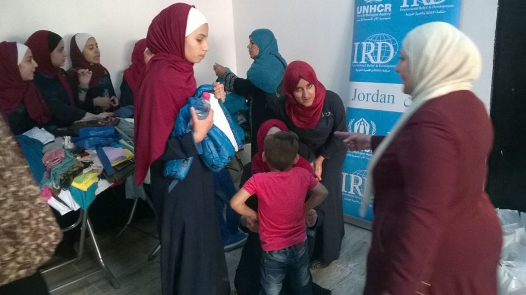 CSC and IPA team members distribute clothing and shoes to refugee families. 