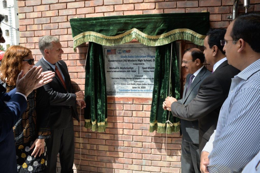 leaders from USAID and SELD unveil plaque for Sukkur school