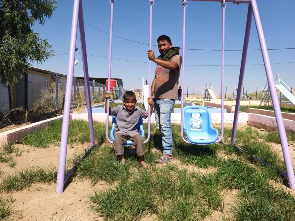 Mohammad on playground swing with father Walid