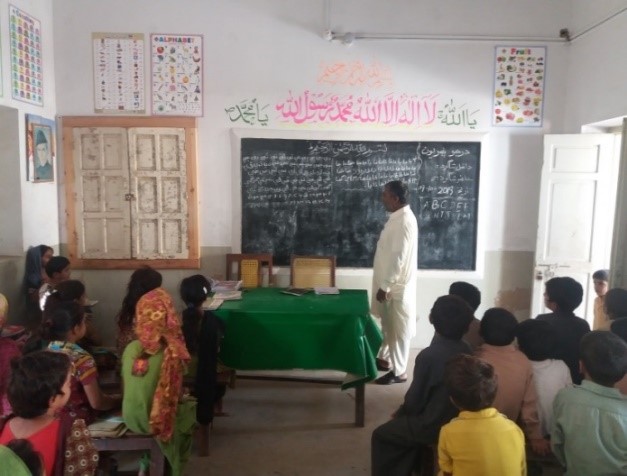 teacher conducting class after increased enrollment in GBPS Larkana District