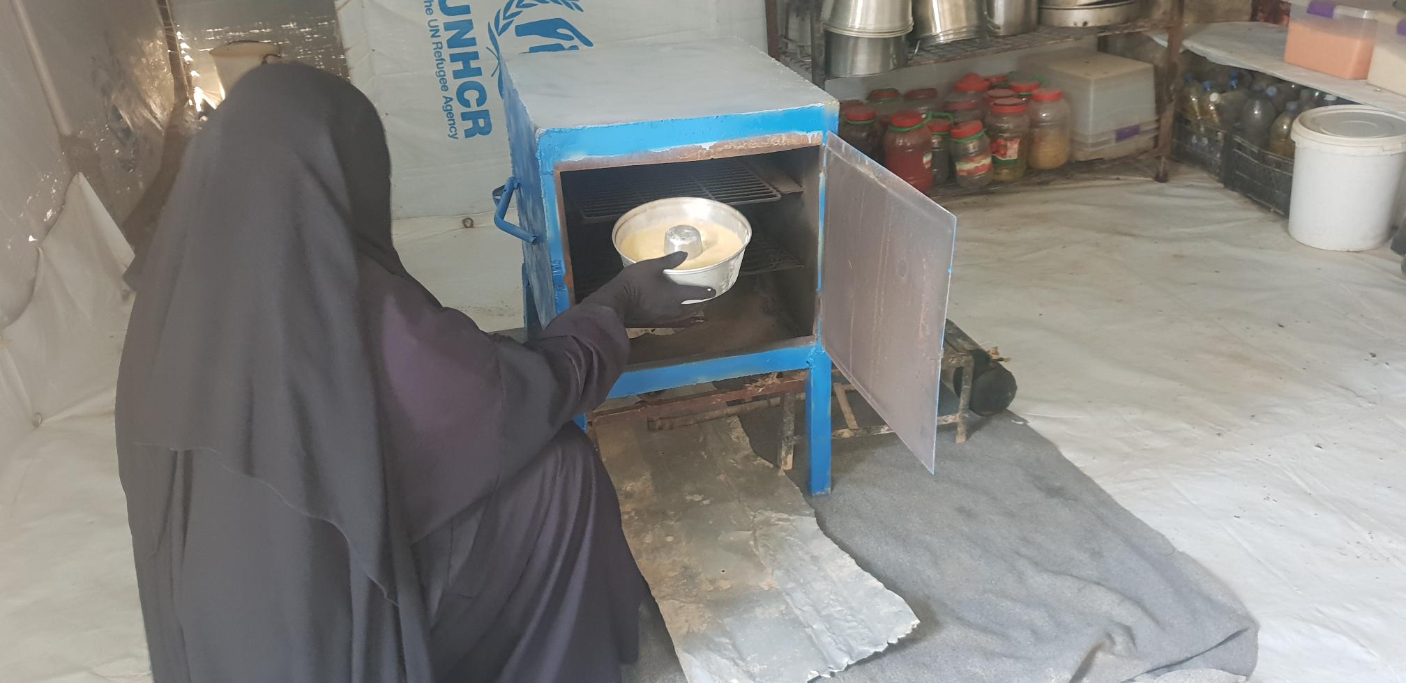 woman placing a cake in the oven