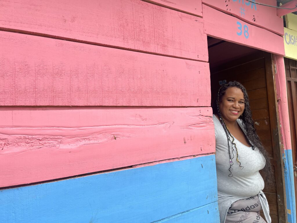 woman standing in doorframe of colorful house