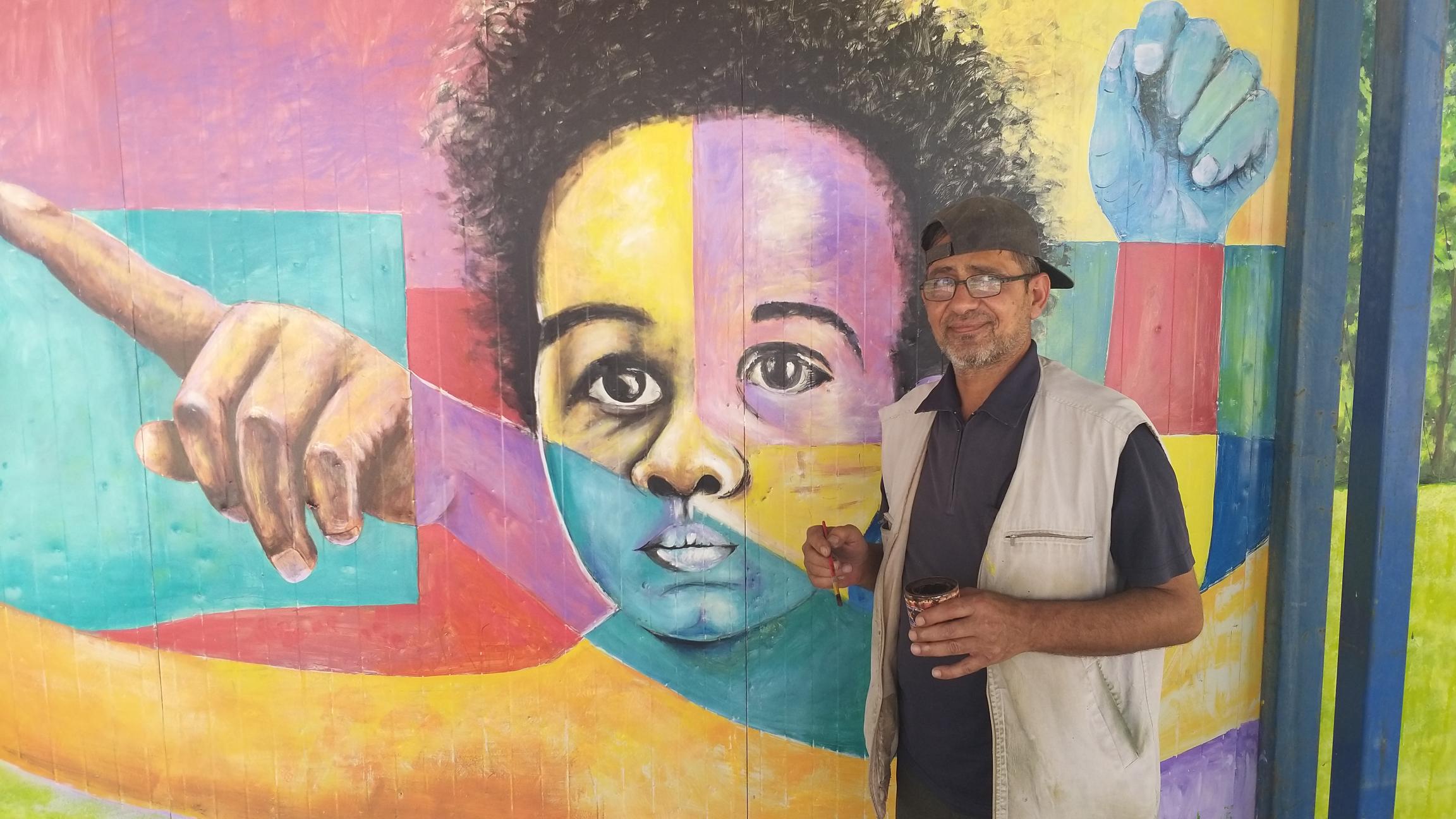 man standing in front of mural