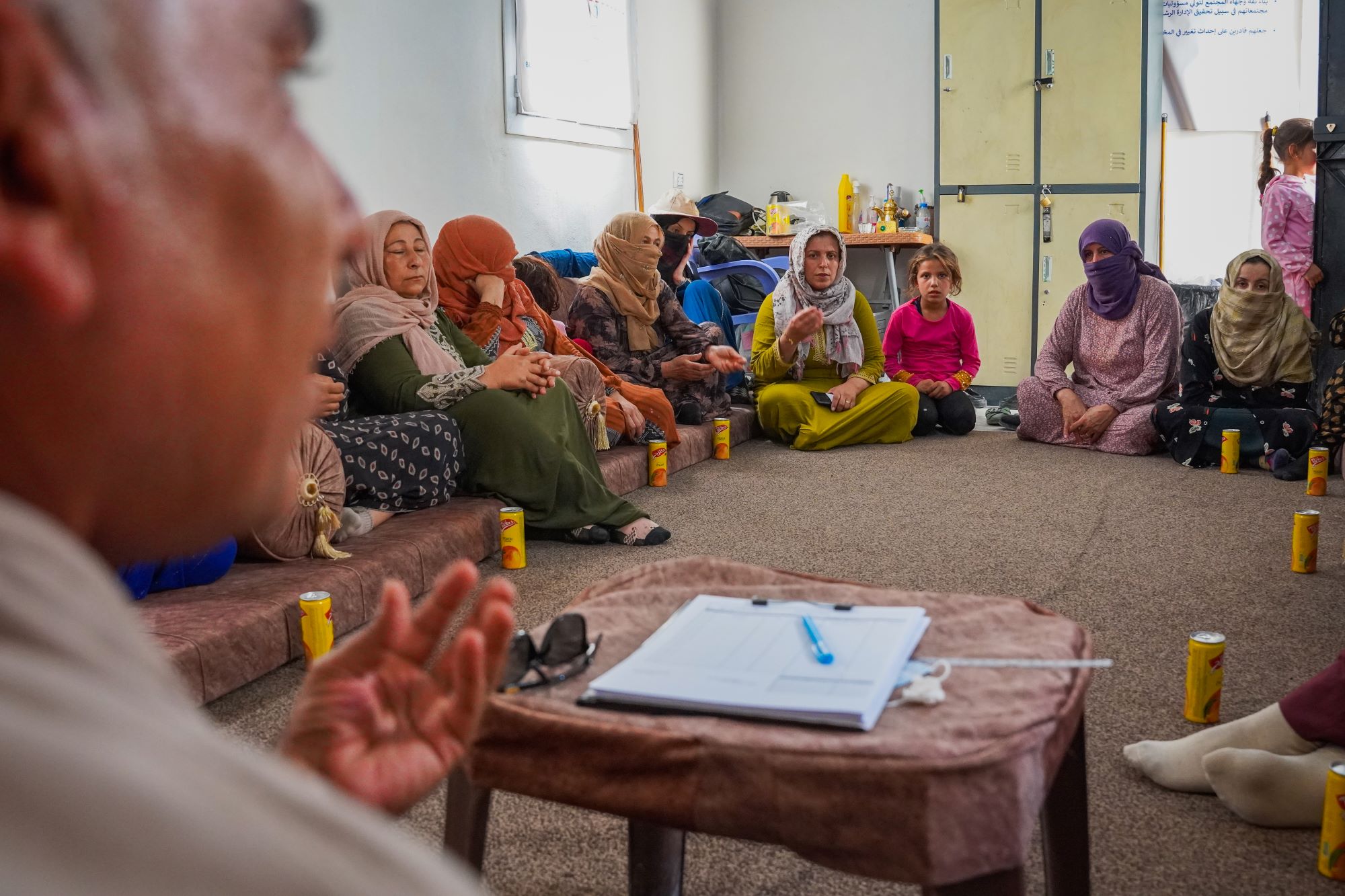 a circle of women and a staff member speaking