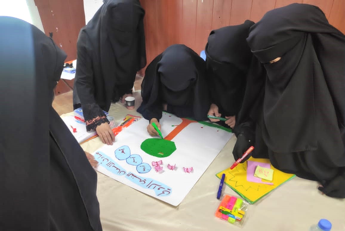 women huddling around a poster